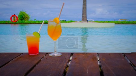 Photo for Close up of cocktails with a swimming pool. Two drinks is standing. Blue turquoise ocean on the background. Summer travel vacation concept. - Royalty Free Image