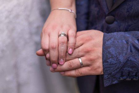 Photo for Close up of hands of a newly wed married couple with wedding rings. Man with an engagement ring with diamond on a finger holding a hand of a woman. High quality photo. - Royalty Free Image