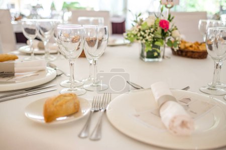 Photo for Wedding reception photo. Glasses and flowers on tables. Wedding restaurant white interior decor, no people. - Royalty Free Image