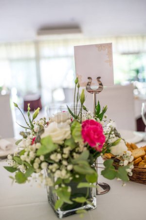 Photo for Wedding reception photo. Glasses and flowers on tables. Empty wedding label. Name tag. Wedding restaurant white interior decor, no people. - Royalty Free Image