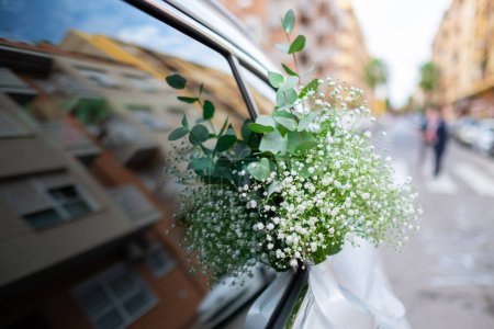 Photo for Close up of luxury wedding car flowers decoration. Nuptial event. Beautiful gypsophila white green flowers. - Royalty Free Image