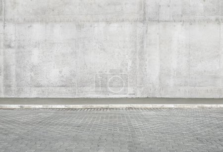 Téléchargez les photos : Un fragment d'un mur de béton de la ville de rue d'un bâtiment et un pavé. Façade du bâtiment. Mocap ou arrière-plan pour la créativité - en image libre de droit