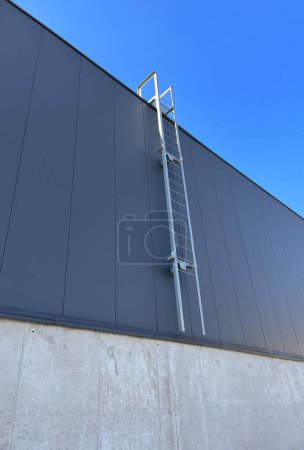 Foto de Escalera técnica en la fachada de un edificio industrial. Salida de incendios. Fachada del edificio - Imagen libre de derechos