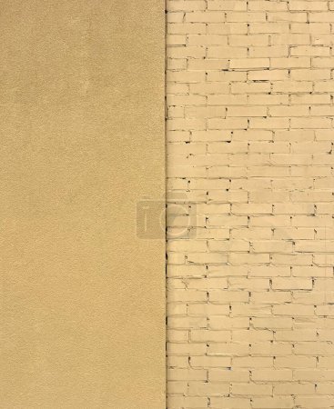 Foto de Fragmento de una pared del edificio con ladrillo y una pared enlucida pintada de amarillo. Textura o patrón - Imagen libre de derechos