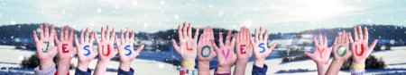 Kinderhände bauen buntes englisches Wort Jesus liebt dich. Weiße Winter Hintergrund mit Schneeflocken und verschneite Landschaft.