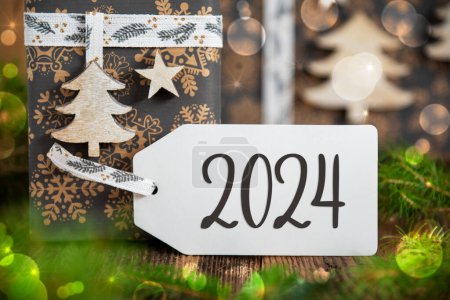 Foto de Texto 2024, En una etiqueta blanca con regalos de Navidad, Regalos de invierno, Natural, Fondo ecológico - Imagen libre de derechos