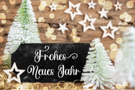 Foto de Árboles de Navidad blancos verdes con fondo rústico de madera y una señal negra con texto alemán Frohes Neues Jahr, que significa feliz año nuevo en inglés - Imagen libre de derechos