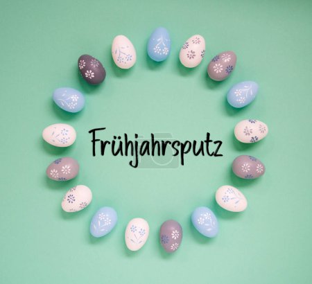 Flat Lay With German Text Fruehjahrsputz Means Spring Cleaning. Easter Egg Arrangement, Decoration And Ornament. Light Green Paper Background