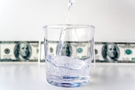 Photo for Water splash from glass with dollar bills background in concept of economic growth - Royalty Free Image