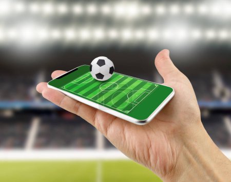 Foto de Cropped shot of a man using a smart phone as football field, watch online, bet online concept at stadium - Imagen libre de derechos