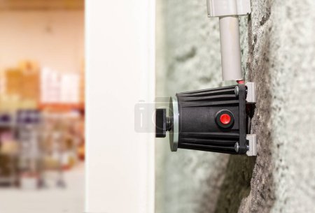 Téléchargez les photos : Close up electromagnetic lock mounted on an aluminum fire door to restrict access to warehouse or factory - en image libre de droit