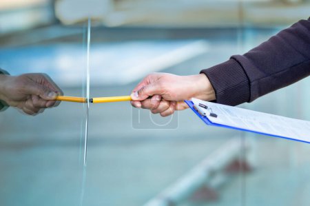 Photo for Close-up of a man's hand checking to repair glass in a store for a window accident - Royalty Free Image