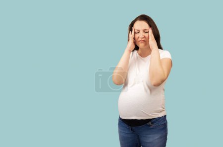 Foto de Young beautiful pregnant woman wearing summer sweater over isolated background suffering from headache desperate with stress because pain and migraine. Hands on head. - Imagen libre de derechos
