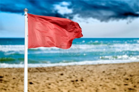 A red warning flag on the beach .Danger to swim in ocean
