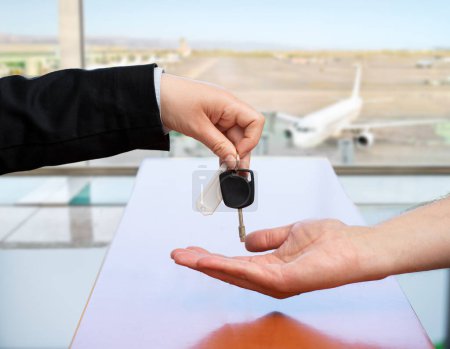 Téléchargez les photos : Cropped shot of unrecognizable stewardess returning giving car key at airport - en image libre de droit