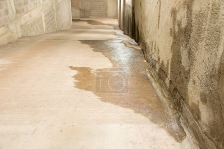 Photo for Entrance to a parking lot with entrance of outside water caused by heavy rains - Royalty Free Image
