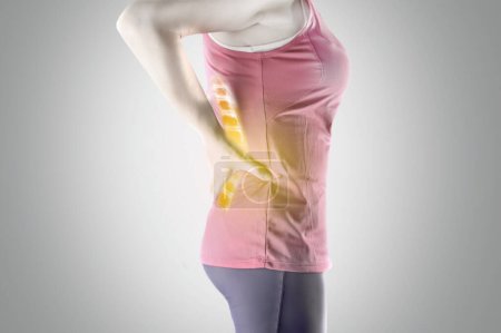 Foto de A cropped view of a sport woman holding her lower back in pain - Imagen libre de derechos