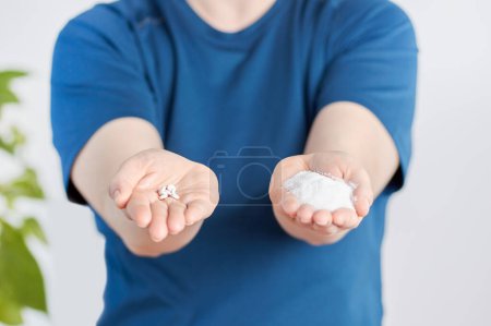 Foto de Vista frontal de cerca de una mujer manos sosteniendo las píldoras de azúcar y sacarina en casa - Imagen libre de derechos