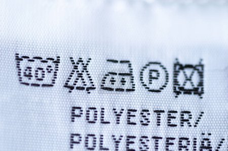 Gros plan d'une étiquette de vêtements avec des instructions d'entretien de la blanchisserie