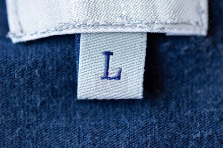 Foto de Macro real de la etiqueta de ropa de tamaño L con fondo azul. - Imagen libre de derechos