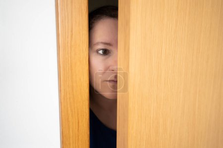 Schnappschuss von Frau, die spioniert und als neugierige Frau durch die Tür eintritt