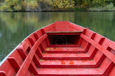 Téléchargez les photos : Bateau vide peint en rouge à la surface de l'eau - en image libre de droit