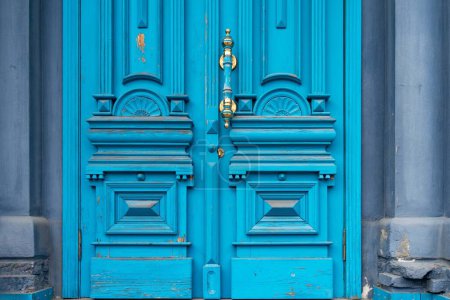 Téléchargez les photos : Porte en bois antique, bleu vif avec motifs sculptés et poignées dorées - en image libre de droit