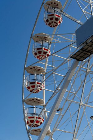 Téléchargez les photos : Cabines de roues Ferris rouges et blanches contre le ciel bleu - en image libre de droit