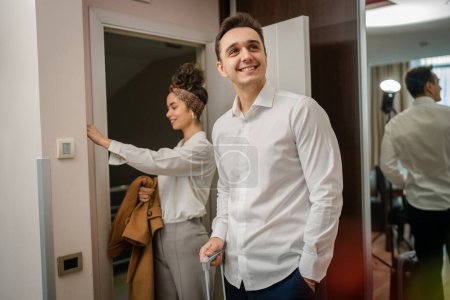 Foto de Couple young man and woman husband and wife or boyfriend and girlfriend entering hotel or motel apartment while on vacation or travel looking to the room wear white shirt real people copy space - Imagen libre de derechos
