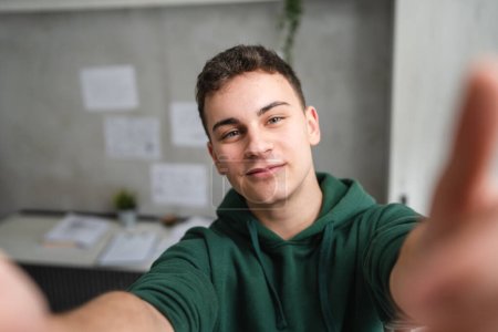 Ein Mann Teenager stehen im Zimmer zu Hause tragen grünen Kapuzenpullover UGC Selfie