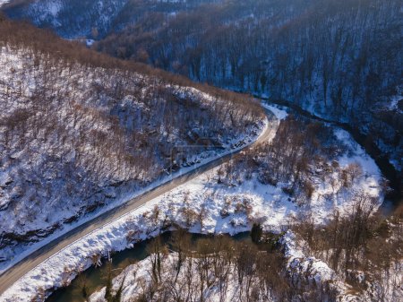Photo for Aerial drone view on the road trough the hill and mountain in winter day covered with snow with rock and trees in Serbia - Royalty Free Image