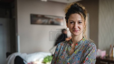 Téléchargez les photos : Une femme heureuse caucasienne debout à la maison ou à l'hôtel appartement - en image libre de droit
