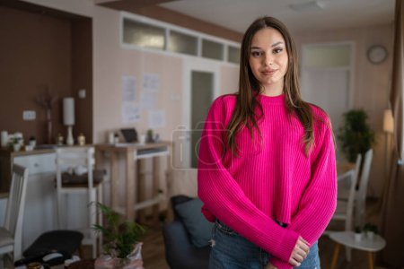 Foto de Front view portrait of one caucasian woman young female stand in her apartment at home wear sweater happy confident real people copy space - Imagen libre de derechos