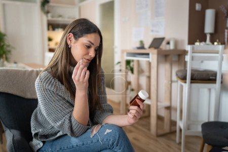Téléchargez les photos : Une femme jeune femme caucasienne tenir médicaments pilules comprimés tout en siégeant à la maison fumée cigarette pensée essayer d'arrêter de fumer personne réelle copier l'espace - en image libre de droit