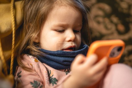 Foto de Una niña pequeña caucásica niño pequeño uso de teléfono inteligente móvil - Imagen libre de derechos
