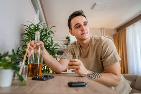 Photo for One man sit at home with bottle of liquor drink whiskey drunk alcoholic Alcohol abuse, addiction and man depression concept copy space - Royalty Free Image