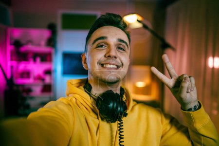 Photo for Self portrait of one man caucasian male streamer blogger or content creator with headphones on his head happy smile confident in his studio copy space user generated content UGC - Royalty Free Image