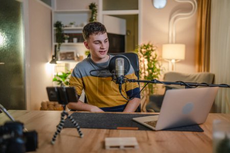 Téléchargez les photos : One man caucasian male blogger or vlogger gesticulating while streaming video podcast in broadcasting studio use microphone and headphones famous influencer shooting video for channel podcast - en image libre de droit