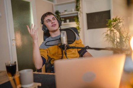 Photo for One man caucasian male blogger or vlogger gesticulating while streaming video podcast in broadcasting studio use microphone and headphones famous influencer shooting video for channel podcast - Royalty Free Image