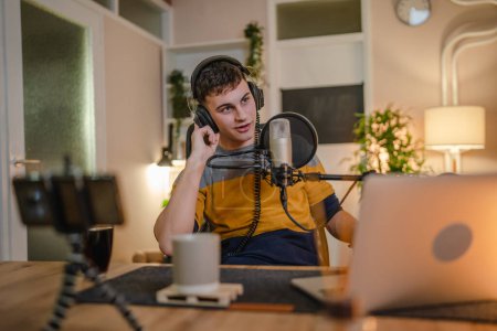 Ein Mann kaukasischen männlichen Blogger oder Vlogger gestikulieren, während Streaming-Video-Podcast im Sendestudio verwenden Mikrofon und Kopfhörer berühmten Influencer Shooting Video für Kanal-Podcast
