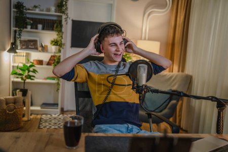 One man caucasian male blogger or vlogger gesticulating while streaming video podcast in broadcasting studio use microphone and headphones famous influencer shooting video for channel podcast