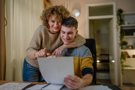 Photo for Young man male student teenager and his mother celebrate scholarship read mail letter happy exited smiling reading entry test results success celebrating achievement concept copy space real people - Royalty Free Image