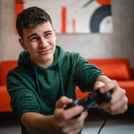 Téléchargez les photos : Un adolescent caucasien mâle jeune homme jouer console jeu vidéo à la maison perdre - en image libre de droit
