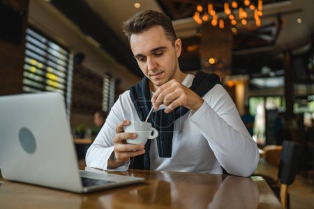 Photo for One man caucasian adult male sitting at the table at cafe restaurant using computer laptop to browse internet or work freelance remote real people copy space - Royalty Free Image