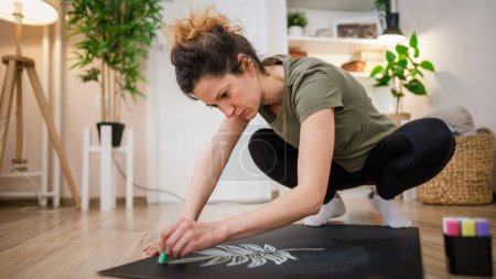 Photo for One woman female artist designer draw on the board on floor with chalk - Royalty Free Image