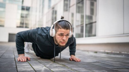 Photo for One man young adult caucasian male training outdoor doing push ups - Royalty Free Image