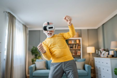Téléchargez les photos : Homme mature vieux caucasien mâle à la maison profiter de réalité virtuelle VR casque - en image libre de droit