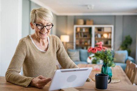 Photo for One mature senior woman grandmother sit at home use credit or debit card for online shopping browse internet stores buying stuff use digital tablet real people copy space - Royalty Free Image