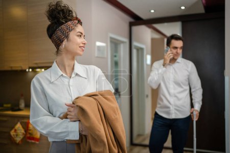 Foto de Couple young woman and man husband and wife or boyfriend and girlfriend entering hotel or motel apartment while on vacation or travel looking to the room wear white shirt real people copy space - Imagen libre de derechos