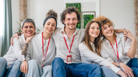 Photo for A group of five professionals one man and four women wearing white shirts standing in a portrait position looking at the camera posing for a business concept photo happy confidence and success - Royalty Free Image